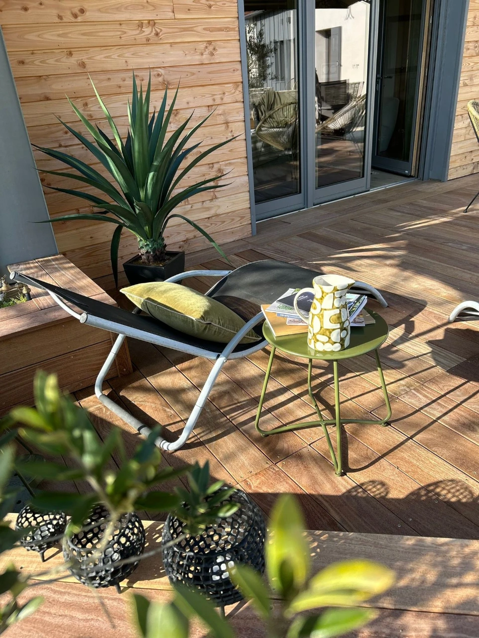 Une grande baie vitrée s’ouvre sur la terrasse attenante, offrant une vue agréable sur le jardin paysager de la propriété. Équipée d’un salon de jardin, c’est l’endroit idéal pour profiter du calme et des beaux jours.
