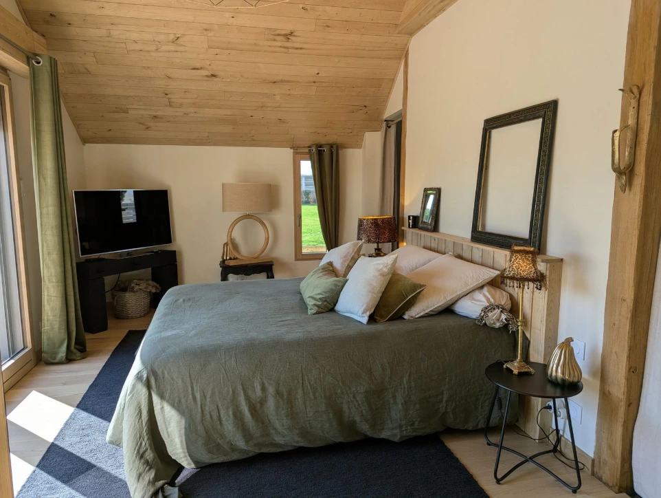 La chambre, spacieuse et lumineuse, dispose d’un confortable lit double (160 × 200) et d’un dressing. La décoration, soigneusement pensée, associe matières naturelles, bois chaleureux et touches contemporaines pour créer une atmosphère cosy et élégante.