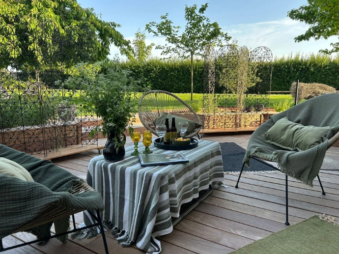 Une grande baie vitrée s’ouvre sur la terrasse attenante, offrant une vue agréable sur le jardin paysager de la propriété. Équipée d’un salon de jardin, c’est l’endroit idéal pour profiter du calme et des beaux jours